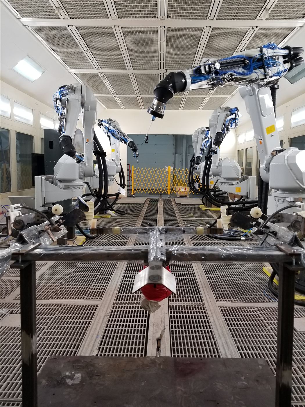 ABB paint robots positioned around a test fixture in a paint booth