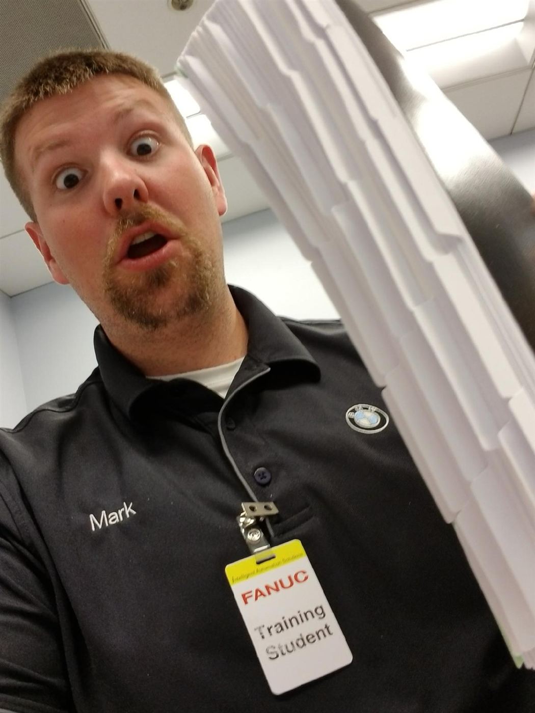 Mark at Fanuc training holding a stack of course manuals